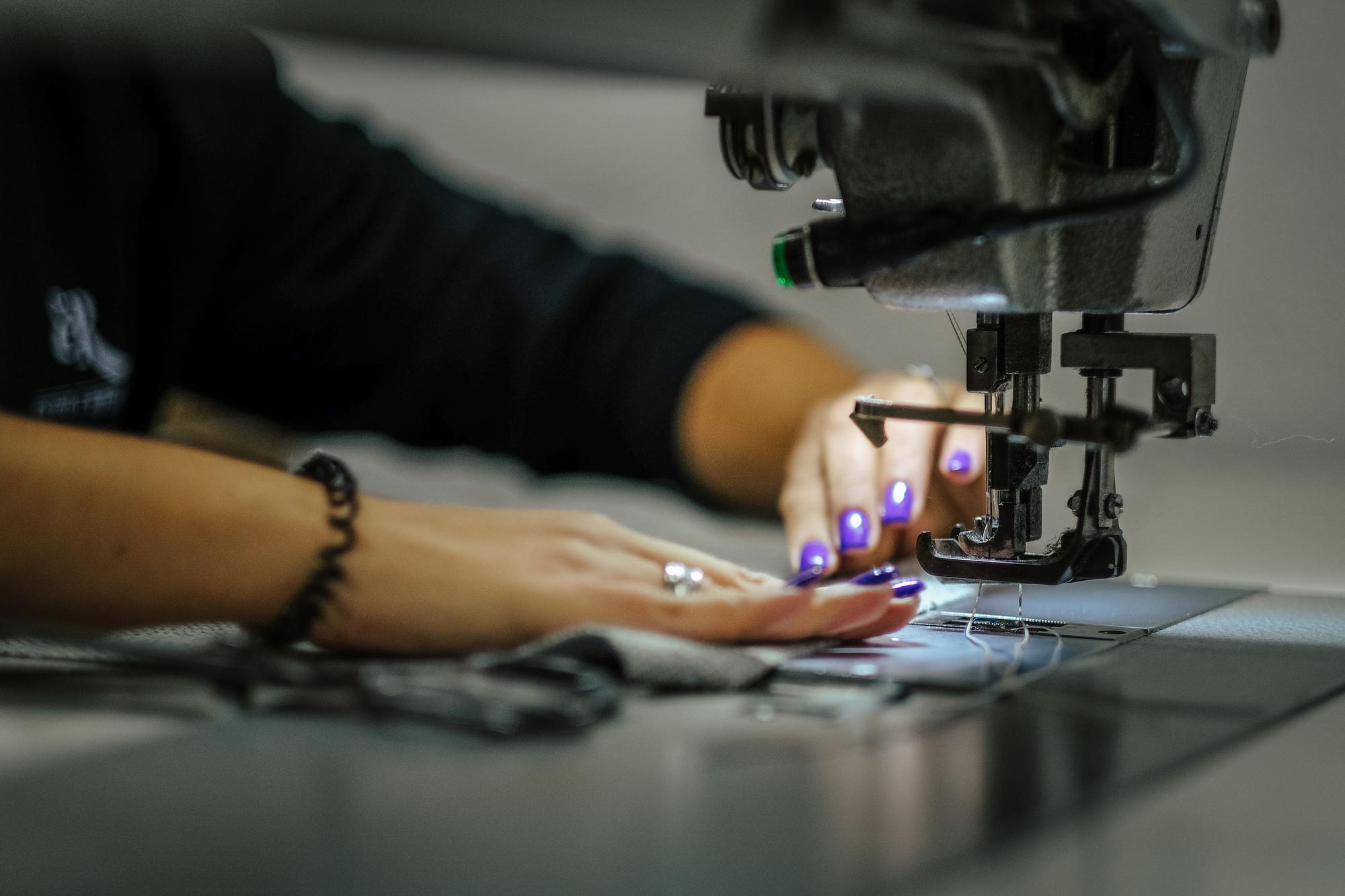hands at embroidery machine finishing a geometric patch